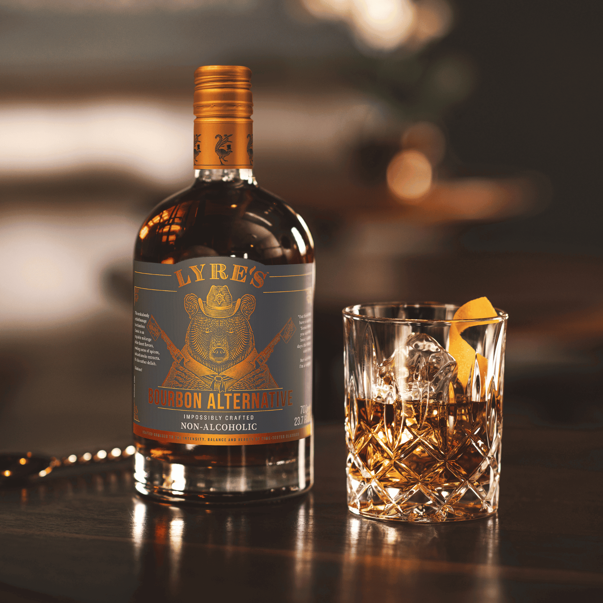 Bottle of Lyre's Non-Alcoholic Bourbon Alternative with a zero proof Old Fashioned cocktail on a bar.