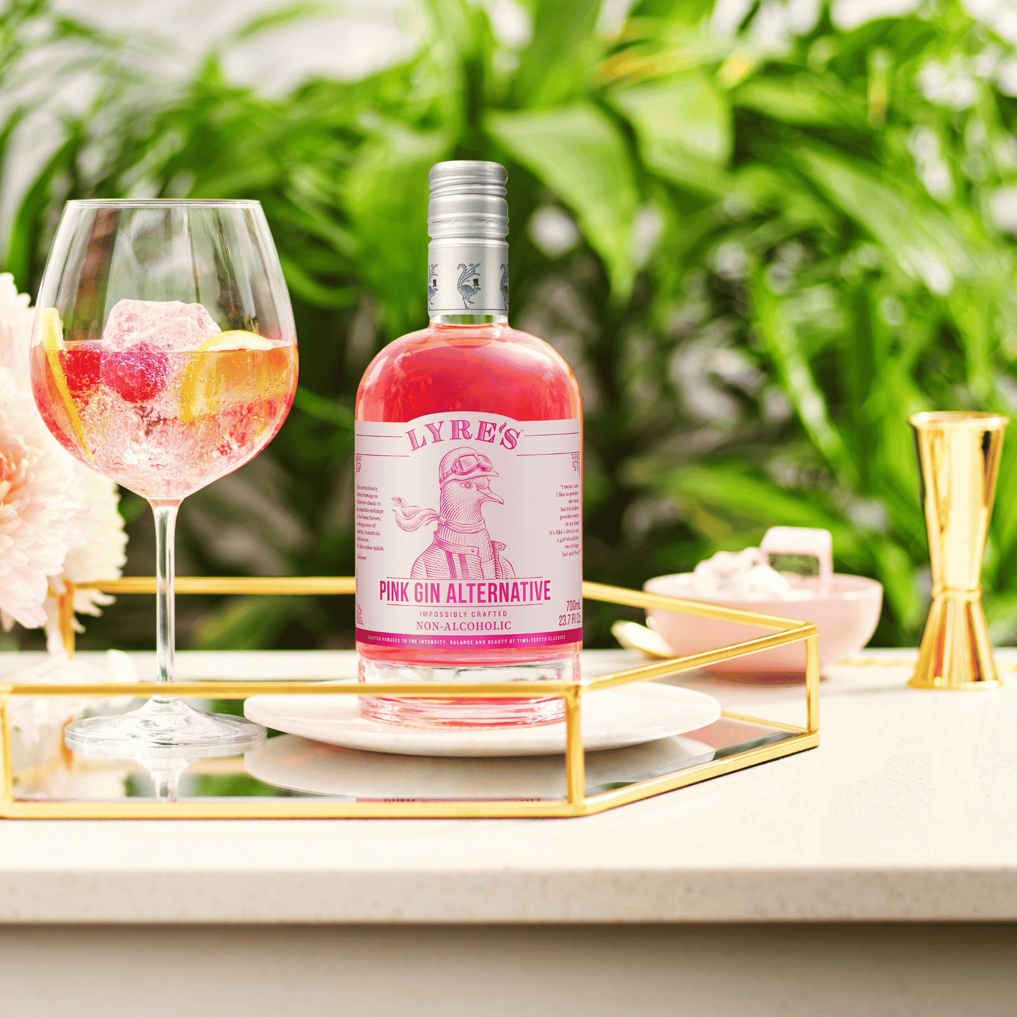 Lyre's Pink Gin Alternative with a glass of pink gin spritz cocktail on a decorative tray.