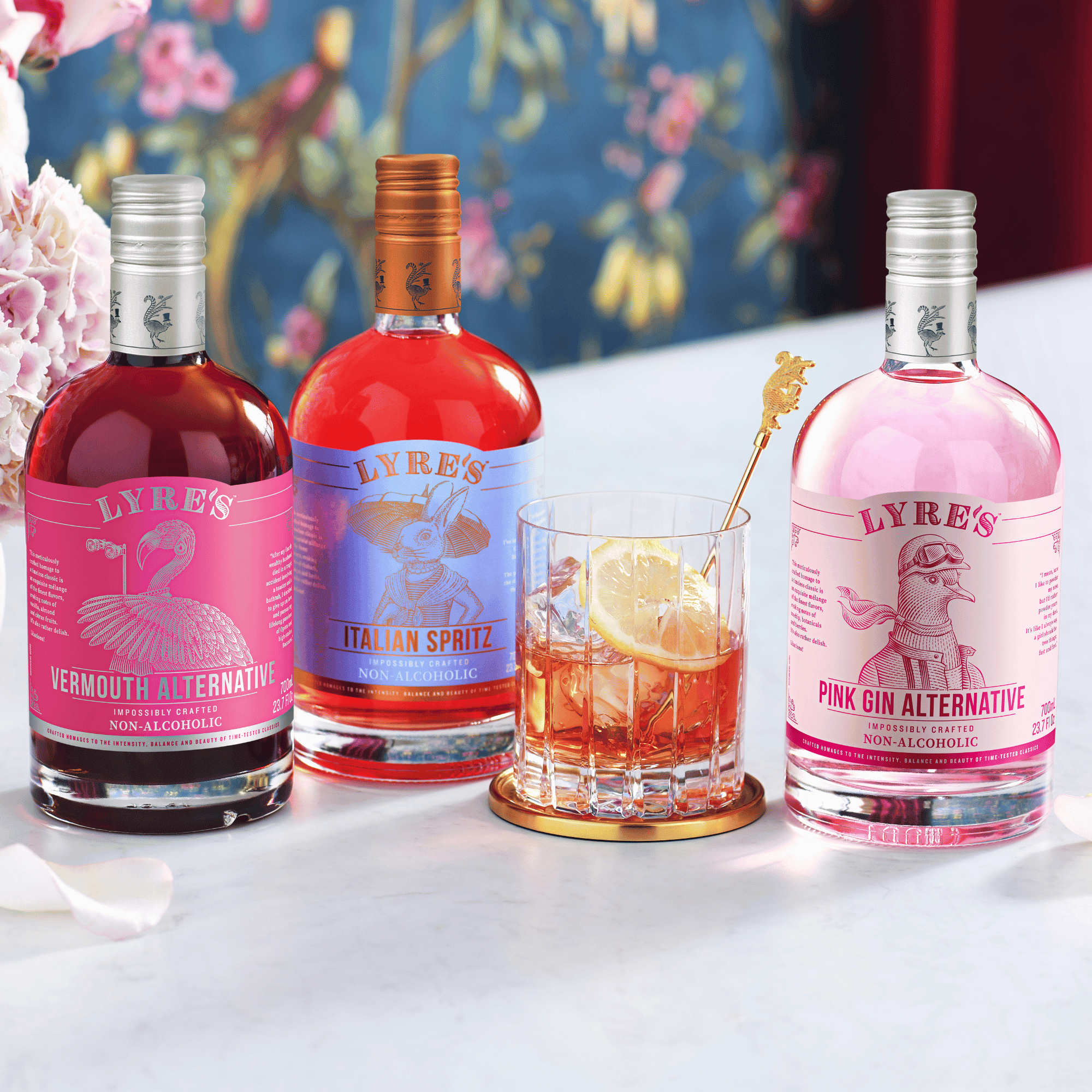 Lyre's Vermouth Alternative, Italian Spritz and Pink Gin alternatives on a table with a Pink Negroni cocktail.