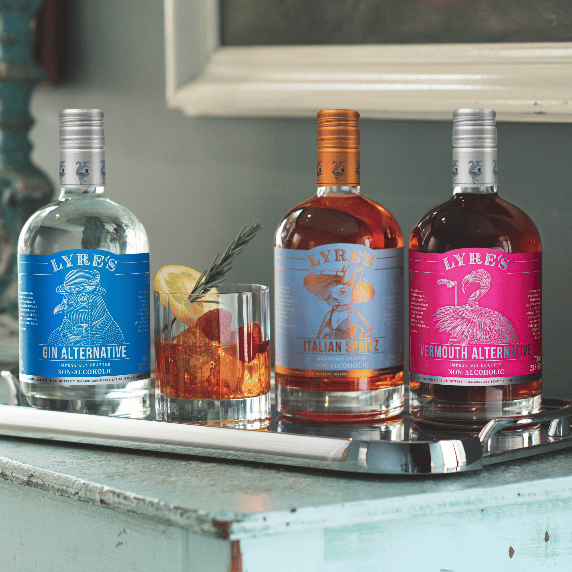 Lyre's Gin Alternative, Italian Spritz and Vermouth Alternative non-alcoholic spirits on a tray with an alcohol free cocktail.